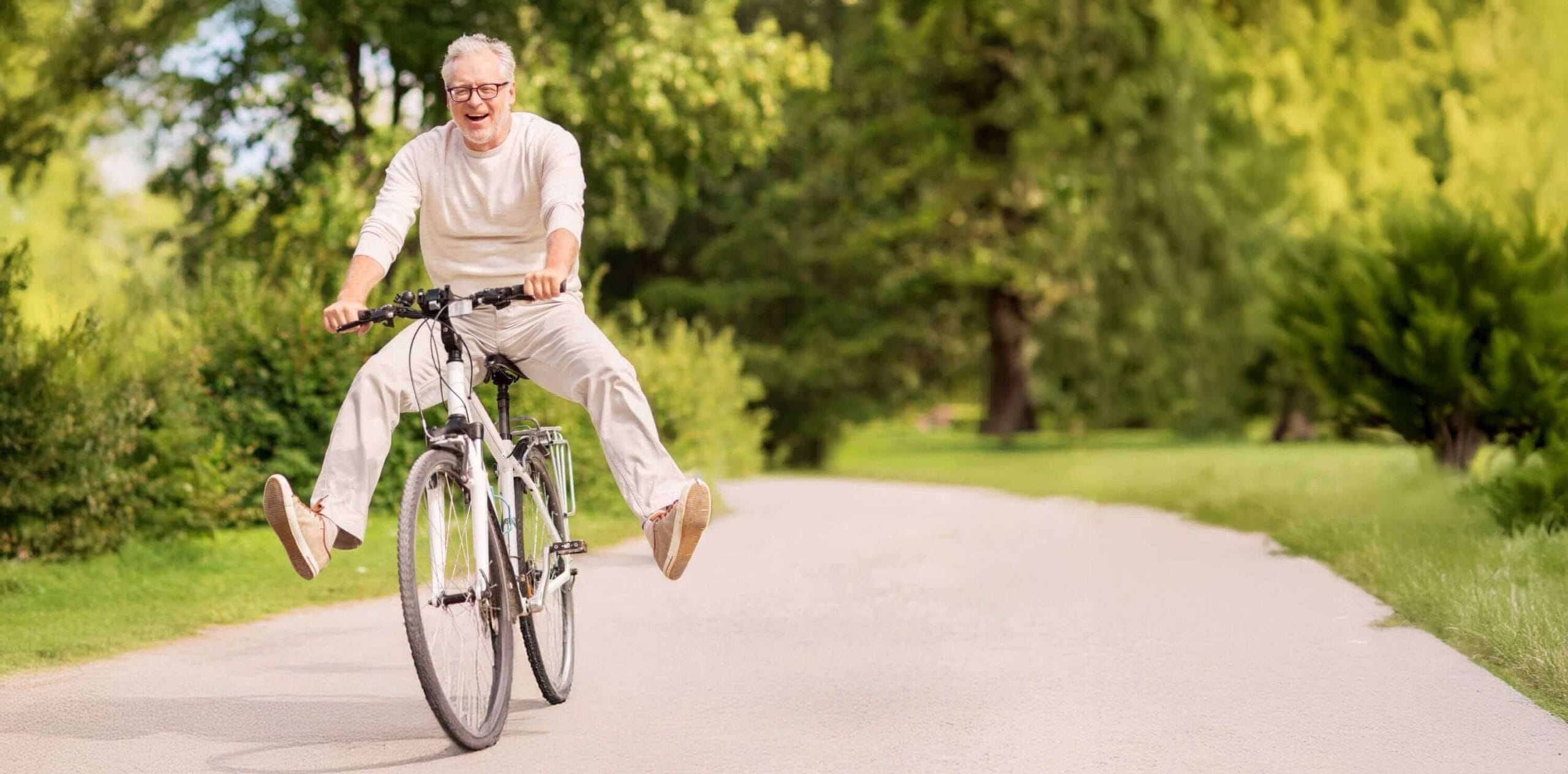 Happy older man riding a bicycle outdoors